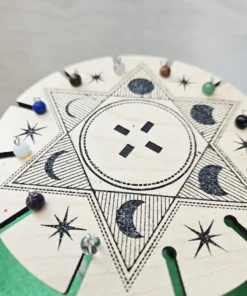 Top view of laser-engraved pendulum stand featuring celestial design and hanging crystals.