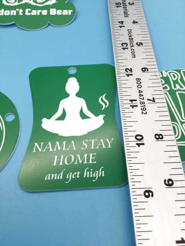 A collection of green and white plastic keychains with cannabis-themed phrase