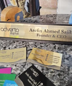 Custom gold metallic desk name plate with CEO title and business logo, displayed with matching business cards.