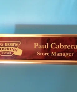 Engraved red marbled and gold desk name plate with custom text and sleek holder, ideal for office or professional use.
