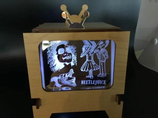 Laser-engraved themed acrylic insert glowing inside vintage-style TV frame
