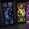 Colorful LED lanterns with intricate cutout designs – sugar skull, crescent moon, reindeer, and Eiffel Tower.