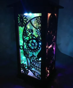 Tall, intricately carved sugar skull lantern illuminated with colorful LEDs, approximately 12 inches in height, perfect for festive or mystical décor.